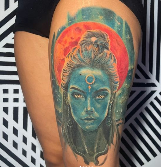 Deusa azul com lua vermelha em surrealismo colorido, tatuagem na coxa