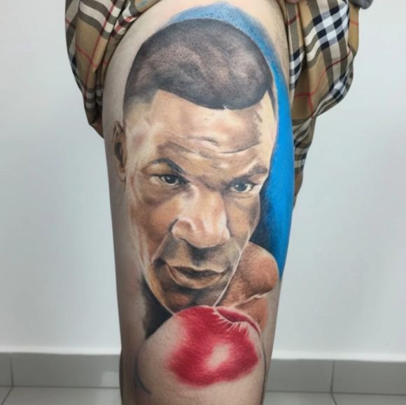 Retrato de boxeador em realismo colorido, tatuagem na coxa