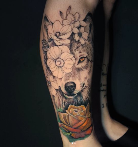 Lobo com flores e rosa em realismo colorido na perna